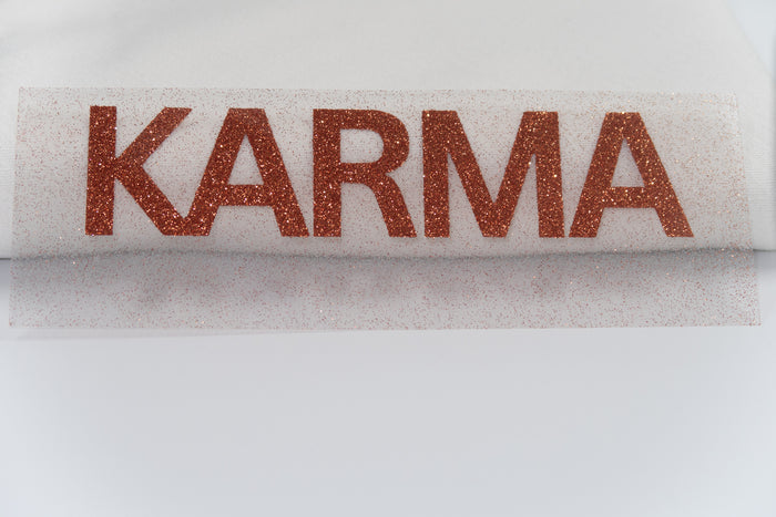 Plot mit der Aufschrift Karma in Glitzerfolie Bronze